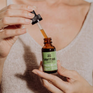 Woman holding opened stress relief drops with filled tincture